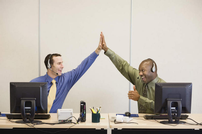 西方人,两个人,伙伴,朋友,商务人士,商务男性,办公室,坐,举,笑,微笑,露齿笑,竖图,室内,白天,正面,衬衫,快乐,通讯,兴奋,友谊,骄傲,成功,胜利,合作,团队,客服,电脑,显示器,鼠标,键盘,家具,桌子,笔筒,欧洲,非洲,黑人,欧洲人,击掌,套装,网络,信息,办公桌,墙,话务员,扭头,注视,输入设备,通讯设备,墙壁,墙面,白色,耳机,耳麦,话筒,容器,观察,看,手势,托,转头,器皿,台式电脑,战略,自信,服务,通信,观看,储藏,协调,察看,麦克风,头戴式耳麦,储存,关注,销售,通信设备,商务装,工薪阶层,输出设备,客服人员,电话销售,办公家具,联合,合谋,接待员,插笔器具,文房用具,配合,协作,男人,男性,中年男性,白种人,非洲人,白领,接线员,上班族,举起,举手,举着,拍手,向上举,向上伸,向上托,坐着,半身,彩图,衬衣,欢乐,开心,贮存,头戴式耳机