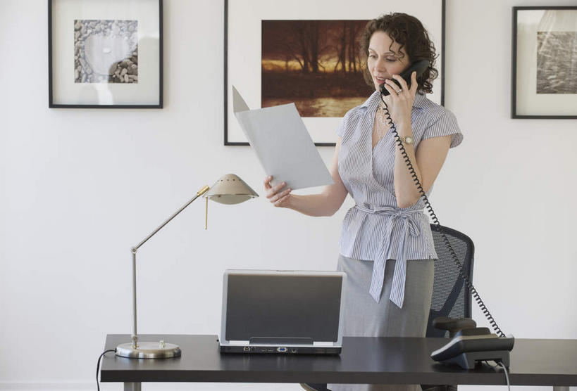 西方人,一个人,商务人士,商务女性,站,打电话,竖图,室内,白天,正面,电脑,笔记本电脑,台灯,桌子,电话,照明,欧洲,欧洲人,仅一个女性,仅一个人,握,套装,网络,材料,档案,文件,办公桌,墙,灯光,拿,听,拿着,注视,通讯设备,墙壁,墙面,灯,白色,话筒,资料,灯具,观察,看,站着,仅一个中年女性,电话线,握着,观看,照亮,察看,无线,固定电话,照明设备,关注,文档,挂画,通信设备,商务装,无线网络,无线上网,便携式电脑,工薪阶层,交流,手提电脑,女人,女性,中年女性,白种人,白领,上班族,电话机,沟通,通话,站立,半身,彩图