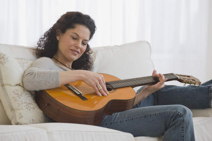 西方人,一个人,客厅,坐,笑,微笑,露齿笑,竖图,室内,白天,正面,窗帘,靠垫,沙发,欧洲,欧洲人,仅一个女性,仅一个人,握,服装,装饰,吉他,靠枕,乐器,弦乐器,弹奏,拿,拿着,注视,休闲装,衣服,帘子,垫子,枕头,观察,看,仅一个中年女性,休闲,休闲服,遮阳,握着,服饰,观看,华丽,修饰,点缀,察看,起居室,关注,弹拨弦鸣乐器,布艺沙发,衬托,美观,雅致,雅观,客堂,女人,女性,中年女性,白种人,坐着,半身,彩图,弹拨弦乐器