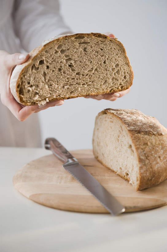 点心,面包,西方人,一个人,站,竖图,室内,特写,白天,正面,桌面,桌子,餐具,欧洲,欧洲人,双手,仅一个年轻女性,仅一个女性,仅一个人,握,阴影,服装,反射,木制,工具,影子,食品,面点,案板,刀具,拿,拿着,休闲装,砧板,食物,糕点,衣服,木制品,刀,站着,休闲,休闲服,黑面包,握着,服饰,全麦面包,餐刀,麸皮面包,年轻女性,女人,女性,白种人,站立,半身,彩图