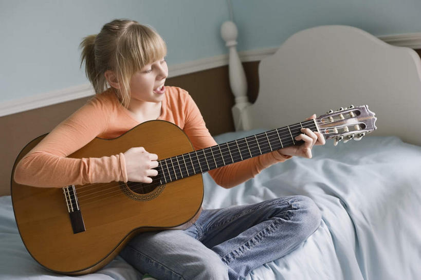 西方人,一个人,坐,横图,室内,白天,正面,床,卧室,欧洲,欧洲人,仅一个年轻女性,仅一个女性,仅一个人,握,服装,双人床,床单,吉他,乐器,弦乐器,弹奏,拿,拿着,注视,休闲装,被子,衣服,观察,看,休闲,休闲服,握着,服饰,观看,察看,被单,关注,弹拨弦鸣乐器,年轻女性,女人,女性,白种人,坐着,半身,彩图,睡房,卧房,弹拨弦乐器