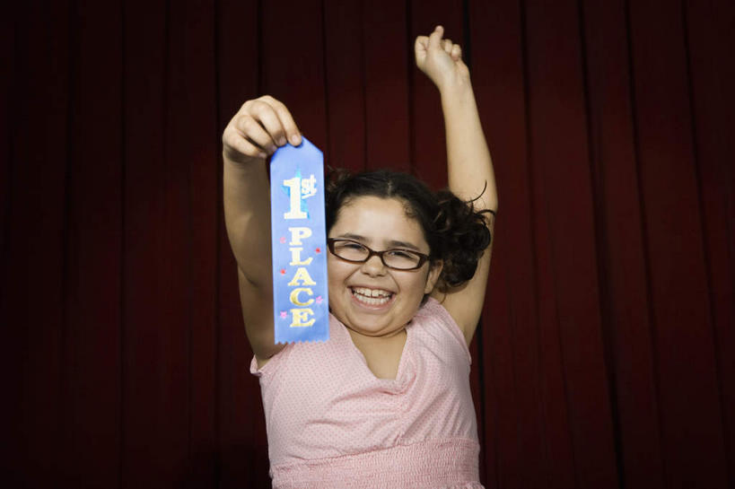 西方人,儿童,一个人,站,举,笑,微笑,露齿笑,横图,室内,白天,正面,纯洁,成功,胜利,欧洲,欧洲人,仅一个女性,仅一个人,握,服装,丝绸,丝带,眼镜,缎带,拿,拿着,注视,休闲装,绸带,一个,小孩,衣服,红色,观察,看,托,站着,仅一个小孩,休闲,休闲服,光彩,可爱,童年,童趣,握着,服饰,帷幕,单个,观看,察看,关注,帷幔,奖牌,幕布,荣誉,幕帘,奖品,近视眼镜,童真,烂漫,无邪,荣耀,帷幔布,光荣,天真,女孩,女人,女性,白种人,孩子,举起,举手,举着,向上举,向上伸,向上托,站立,半身,彩图,女生