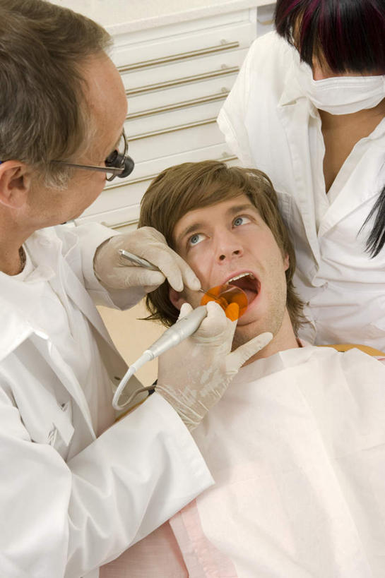 西方人,三个人,医生,病人,牙科医生,医院,站,躺,竖图,俯视,室内,白天,工作服,制服,机器,仪器,欧洲,欧洲人,握,阴影,检查,反射,分离,分析,科学,医学,放大镜,影子,过滤,拿,分开,拿着,注视,设备,口罩,手套,观察,看,站着,张嘴,医护人员,医疗人员,隔断,橡胶,清晰,探索,握着,遮掩,放大,观看,隔离,仔细,透镜,察看,医疗,医疗设备,卫生,掩盖,凸透镜,遮挡,聚焦,白大褂,关注,净化,病患,间隔,医疗器械,橡胶手套,预防,医疗工具,张大嘴巴,橡胶制品,遮盖,防尘,医疗机构,牙钻,医用手套,光学,清楚,掩饰,断绝,隔开,屏蔽,屏绝,远离,中断,阻遏,阻隔,工作制服,检测工具,双目立体放大镜,卧着,男人,男性,年轻男性,年轻女性,女人,女性,中年男性,白种人,大夫,患者,就医者,牙医,张开嘴,躺着,卧,站立,半身,彩图,高角度拍摄,工作套服,病院,诊所,牙科椅,牙科治疗椅,牙椅