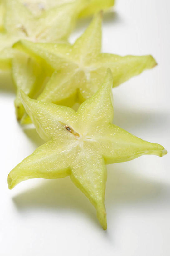 无人,竖图,俯视,室内,特写,白天,白色背景,桌面,桌子,水果,切开,阴影,新鲜,反射,木制,影子,星星,生食,食品,果实,食物,木制品,杨桃,切,星形,摄影,有机食品,绿色食品,影棚,五敛子,三廉子,阳桃,洋桃,剖面,五角形,切面,五角星,彩图,高角度拍摄,影棚拍摄,拍摄