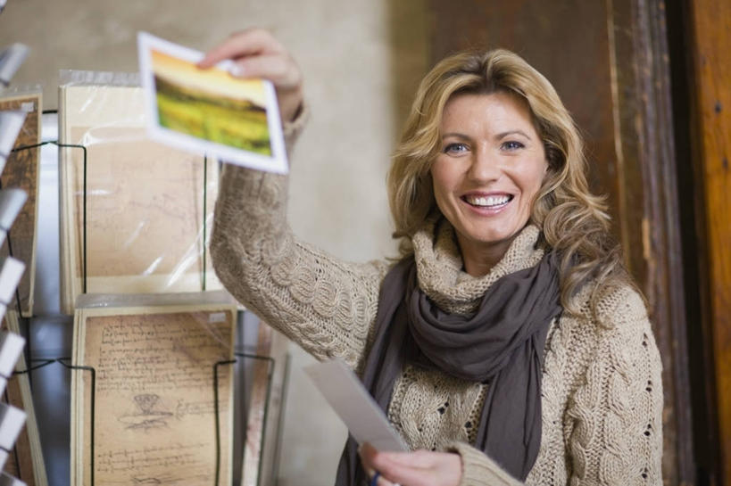 西方人,一个人,商店,站,举,笑,微笑,露齿笑,横图,室外,白天,正面,欧洲,欧洲人,仅一个女性,仅一个人,许多,握,阴影,服装,装饰,反射,传递,信息,影子,墙,明信片,联系,注视,休闲装,商铺,货架,架子,墙壁,墙面,排列,衣服,白色,卡片,围巾,观察,看,托,站着,仅一个中年女性,休闲,温暖,休闲服,联络,握着,通信,服饰,围脖,观看,纪念,留念,保暖,华丽,点缀,察看,御寒,队列,关注,陈列架,怀念,宣传,衬托,美观,雅致,雅观,市肆,商号,记念,女人,女性,中年女性,白种人,举起,举手,举着,向上举,向上伸,向上托,站立,半身,彩图,店铺,收藏