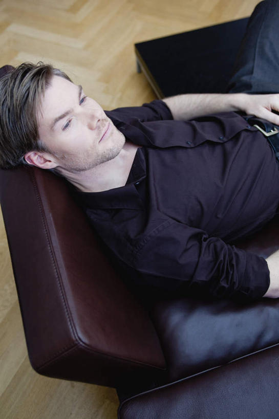 西方人,一个人,客厅,坐,竖图,俯视,室内,白天,地板,沙发,欧洲,欧洲人,仅一个男性,仅一个人,仅一个中年男性,服装,地面,注视,休闲装,木地板,衣服,观察,看,休闲,休闲服,服饰,观看,察看,起居室,关注,客堂,男人,男性,中年男性,白种人,坐着,半身,彩图,高角度拍摄,皮沙发