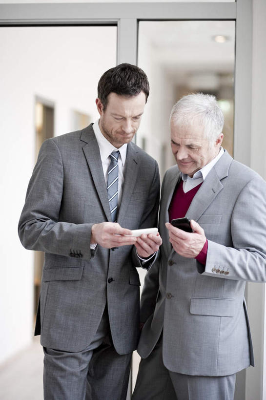 西方人,两个人,伙伴,朋友,商务人士,商务男性,办公室,站,笑,打电话,微笑,露齿笑,竖图,室内,白天,正面,衬衫,友谊,合作,团队,窗户,门,电话,手机,欧洲,欧洲人,握,套装,墙,走道,走廊,过道,拿,拿着,注视,通讯设备,玻璃窗,墙壁,墙面,门框,观察,看,站着,战略,握着,观看,察看,关注,商务装,工薪阶层,联合,合谋,交流,配合,协作,老年男性,男人,男性,中年男性,白种人,白领,上班族,沟通,通话,站立,半身,彩图,衬衣