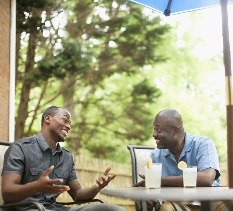 冲浪,西方人,两个人,伙伴,朋友,坐,笑,说,微笑,露齿笑,室外,白天,正面,讨论,友谊,植物,桌面,桌子,柠檬,杯子,水果,椅子,欧洲,非洲,黑人,欧洲人,服装,朦胧,模糊,新鲜,木制,伞,雨伞,遮阳伞,木椅,生食,汽水,食品,果实,柠檬水,饮品,注视,休闲装,阳伞,玻璃制品,树,树木,食物,饮料,衣服,绿色,自然,木制品,水杯,碳酸饮料,观察,看,休闲,休闲服,服饰,有机食品,绿色食品,生长,成长,观看,察看,太阳伞,关注,可口,适口,交流,友情,男人,男性,年轻男性,中年男性,非洲人,玻璃杯,益母果,柠果,沟通,讲话,交谈,商讨,说话,谈话,坐着,半身,彩图,荷兰水