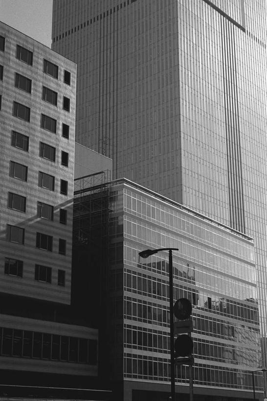 无人,高楼大厦,竖图,黑白,室外,白天,仰视,旅游,度假,安全,大厦,建筑,路灯,摩天大楼,阴影,光线,影子,红绿灯,信号灯,交通,娱乐,灯,阳光,享受,休闲,放松,警示,照明设备,提示,流通,交通信号灯,行人信号灯,低角度拍摄,大楼,高层建筑,高楼,摩天楼