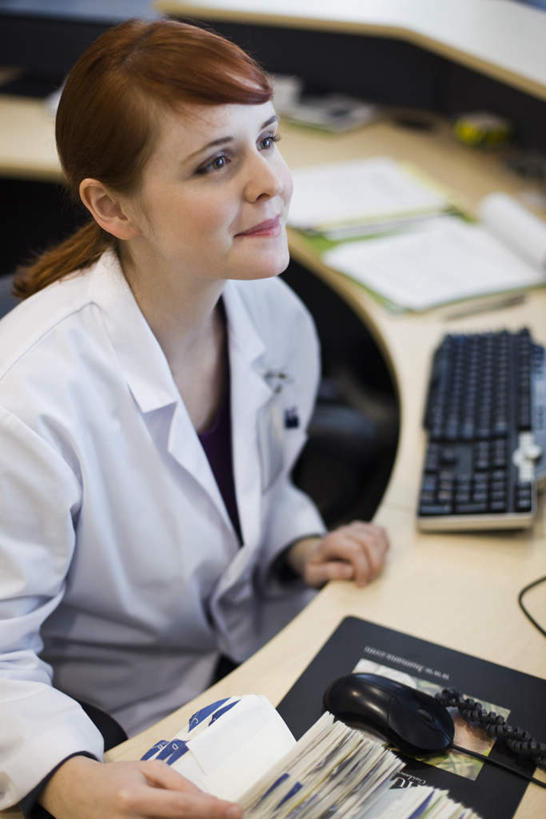 西方人,一个人,医生,医院,坐,笑,微笑,竖图,俯视,室内,白天,鼠标,键盘,欧洲,欧洲人,仅一个年轻女性,仅一个女性,仅一个人,便签,注视,输入设备,通讯设备,柜台,看,医护人员,医疗人员,关注,通信设备,医疗机构,年轻女性,女人,女性,白种人,大夫,抬头,仰头,坐着,半身,彩图,高角度拍摄,病院,诊所