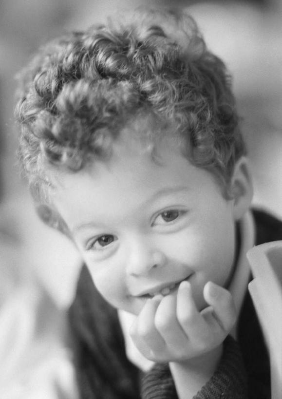 西方人,儿童,一个人,坐,笑,微笑,露齿笑,竖图,黑白,室内,白天,正面,纯洁,欧洲,欧洲人,仅一个男性,仅一个人,撑,朦胧,模糊,托腮,小孩,托,仅一个小孩,可爱,童年,童趣,托下巴,童真,烂漫,无邪,天真,男孩,男人,男性,白种人,孩子,坐着,半身,男生