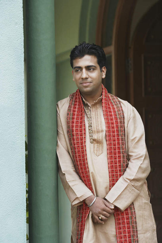 一个人,站,竖图,室外,白天,正面,民族服装,亚洲,仅一个男性,仅一个人,服装,装饰,柱子,注视,仅一个年轻男性,衣服,绿色,围巾,观察,看,靠,靠着,倚靠,站着,温暖,服饰,围脖,观看,保暖,华丽,点缀,察看,倚着,衣着,御寒,穿着,关注,衬托,美观,雅致,雅观,衣饰,男人,男性,年轻男性,亚洲人,印度人,站立,半身,彩图,传统服装,民俗服