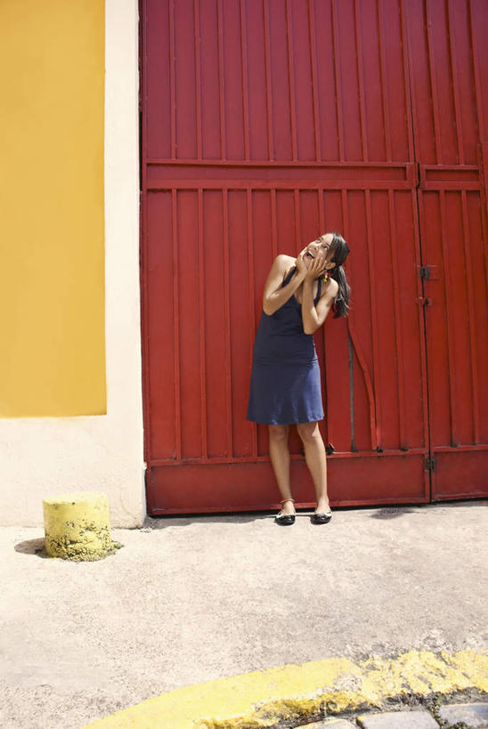 西方人,一个人,站,笑,微笑,露齿笑,竖图,室外,白天,正面,鞋,门,道路,路,鞋子,金属制品,欧洲,欧洲人,仅一个年轻女性,仅一个女性,仅一个人,一双,撑,服装,金属,墙,小路,皮革,交通,托腮,休闲装,墙壁,墙面,衣服,黄色,红色,白色,黑色,门框,托,站着,休闲,辫子,休闲服,服饰,托下巴,年轻女性,女人,女性,白种人,长发,抬头,仰头,站立,彩图,全身,皮鞋