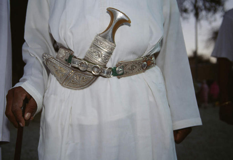 一个人,站,横图,室外,白天,正面,民族服装,竞争,亚洲,仅一个男性,仅一个人,对抗,朦胧,模糊,装饰,冲突,刀具,破坏,腰带,仅一个年轻男性,刀,站着,武器,战争,皮带,华丽,修饰,损坏,点缀,攻击,威胁,对立,矛盾,兵器,防御,配饰,敌对,挫败,斗争,抗拒,抗衡,衬托,美观,雅致,雅观,凶器,杀伤,威慑,裤带,危险,男人,男性,年轻男性,阿拉伯人,白种人,亚洲人,站立,半身,彩图,传统服装,民俗服,匕首