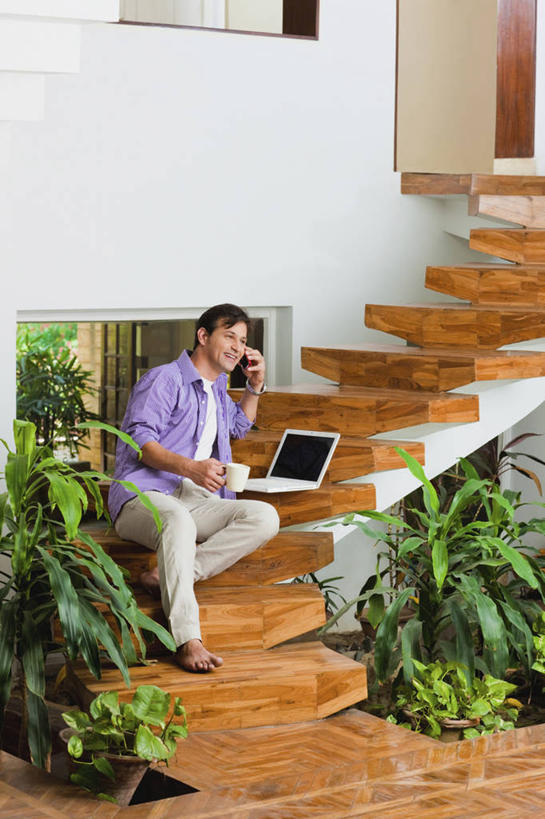 一个人,坐,打电话,微笑,竖图,室内,白天,快乐,通讯,笔记本电脑,技术,楼梯,手机,印度,敲打,木制,首都,拿着,休闲装,输入,马克杯,打字,赤脚,放松,摄影,宁静,点击,敲击,肖像,新德里,无线电技术,丝兰,按键,印度人,彩图